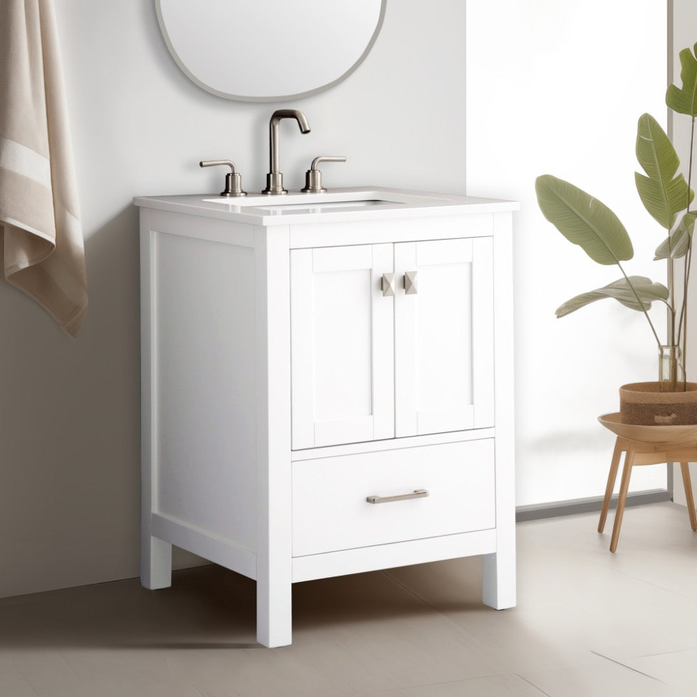 The Vanea 24 inch Bathroom Vanity in White with White Quartz Top features a modern sink, silver faucets, double-door cabinet, and a lower drawer. A round mirror, towel, and potted plant enhance the bright, minimalistic space.