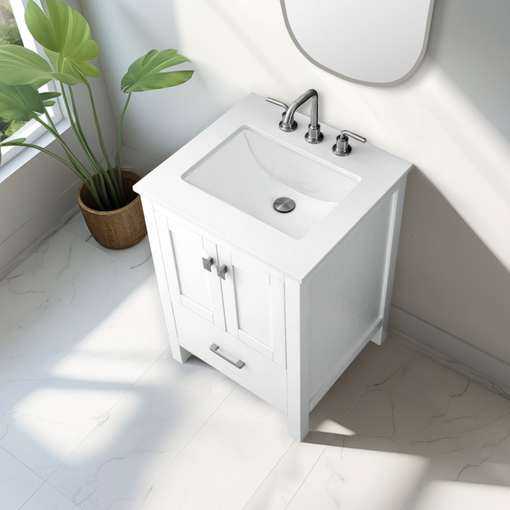 The Vanea 24 inch Bathroom Vanity in White with White Quartz Top features a sleek design, standing on a tiled floor beside a potted plant, all bathed in sunlight from a nearby window.