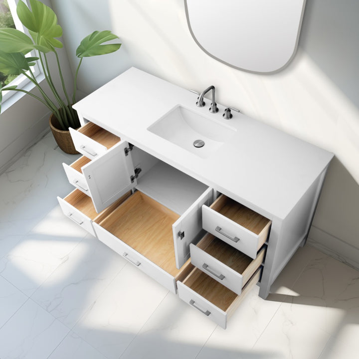 A Vanea 60 inch Single Bathroom Vanity in White with a White Quartz Top, built-in sink, and chrome faucet is shown from above with all drawers and cabinet doors open; interiors are empty. A green potted plant sits nearby on the sunny tiled floor.