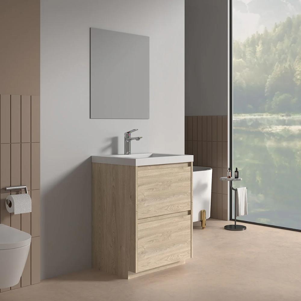 A modern bathroom featuring the Arvia 24 inch Bathroom Vanity with Sink, a wall-mounted faucet, large mirror, toilet, toilet paper holder, and floor-to-ceiling window overlooking a green forest and lake.