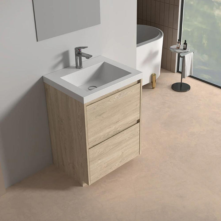 A modern bathroom features the Arvia 24 inch Bathroom Vanity with Sink in light wood, a wall-mounted faucet, a bathtub in the background, and a small toiletries table near a large window.