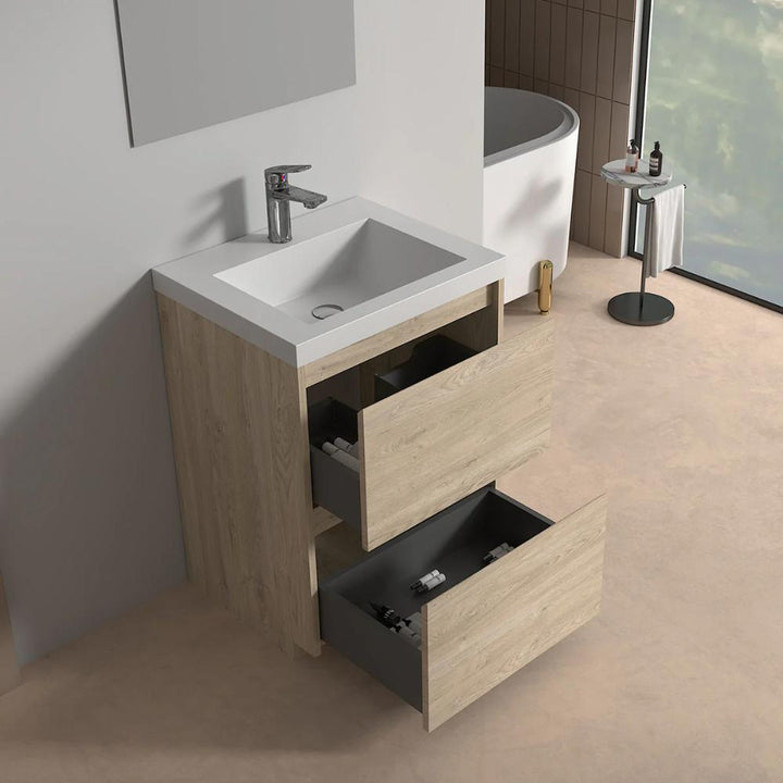 A modern bathroom with the Arvia 24 inch Bathroom Vanity with Sink in wood finish, featuring two open drawers, next to a white bathtub and round side table with toiletries by a large window.