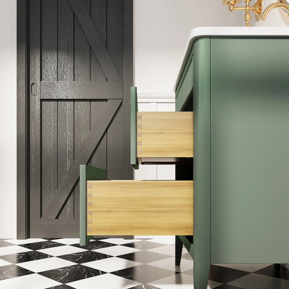A green Aveline 30 Inch Freestanding Bathroom Vanity With Top with two partially open wooden drawers stands on a black-and-white checkered floor beside a black barn-style door in a bright room.