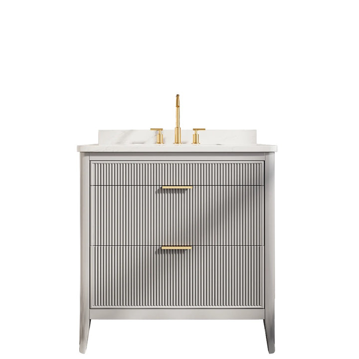 The Aveline 36 Inch Freestanding Bathroom Vanity With Top features a ribbed gray finish, two drawers with gold handles, a white countertop, and elegant gold faucet fixtures for a modern touch.