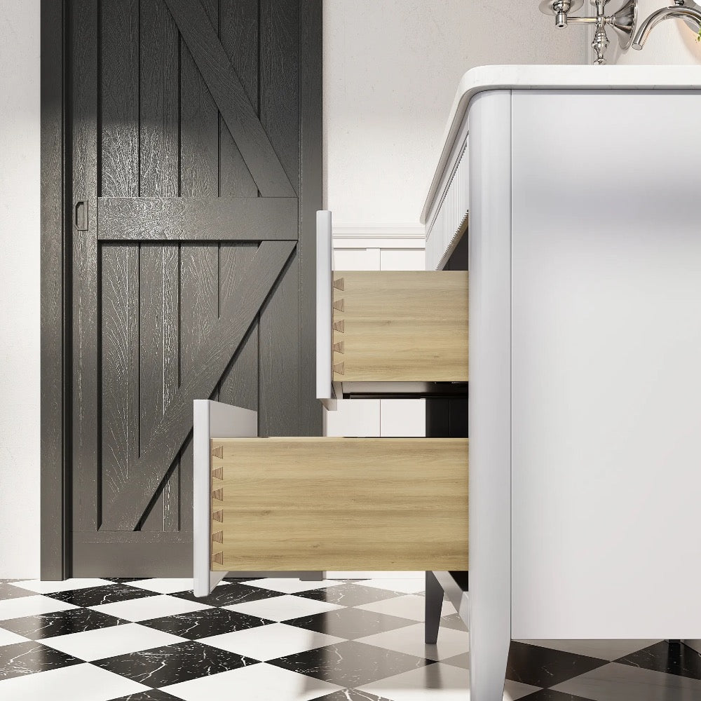 The Aveline 30 Inch Freestanding Bathroom Vanity With Top features two wooden drawers open, set on a black and white checkered tile floor beside a dark barn-style door and a chrome faucet.