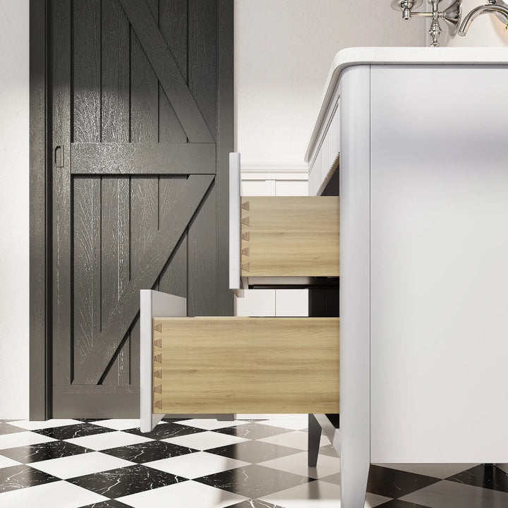 The Aveline 30 Inch Freestanding Bathroom Vanity With Top features two wooden drawers open, set on a black and white checkered tile floor beside a dark barn-style door and a chrome faucet.