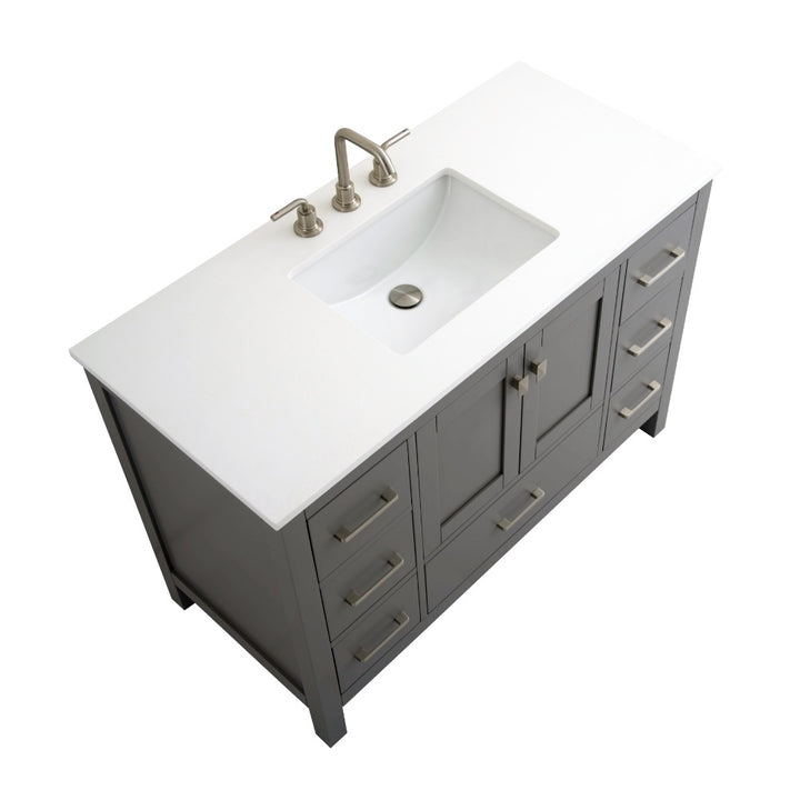 The Vanea 48 inch Bathroom Vanity in Gray with White Quartz Top features a modern design, built-in rectangular sink, brushed metal faucet, and offers multiple drawers and cabinets for storage.
