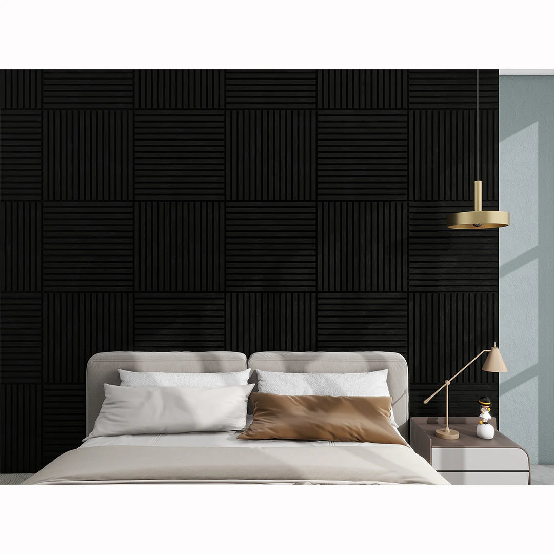 A modern bedroom features a beige bed with pillows, a side table and lamp, and the Acoustic Interior Wall Panel with a geometric grid of square panels. A gold pendant light above adds elegance to the space.
