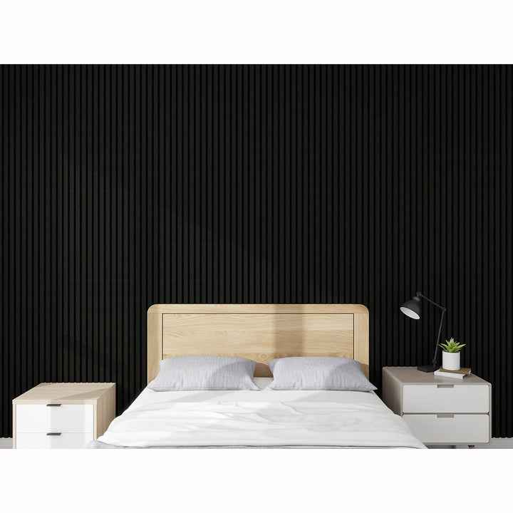A modern bedroom featuring the Acoustic Interior Wall Panel in black as an accent wall, with a light wooden bed frame, white bedding, two white nightstands, a black desk lamp, and a small plant.