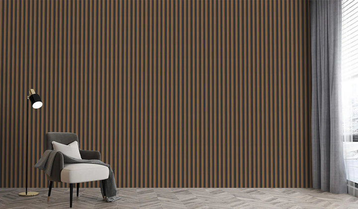 A modern interior showcases a 3D Interior Wall Panel with brown and black stripes, a white and gray armchair draped with a blanket, a gold floor lamp, and sheer gray curtains on the window letting in natural light.