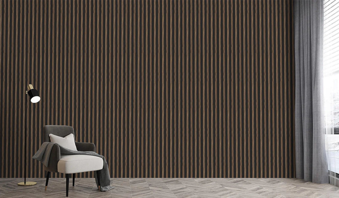 A modern minimalist room features a gray armchair, black floor lamp, and the 3D Interior Wall Panel with black-and-brown vertical stripes. Sunlight streams through sheer white curtains on tall windows; a pillow and blanket rest on the chair.