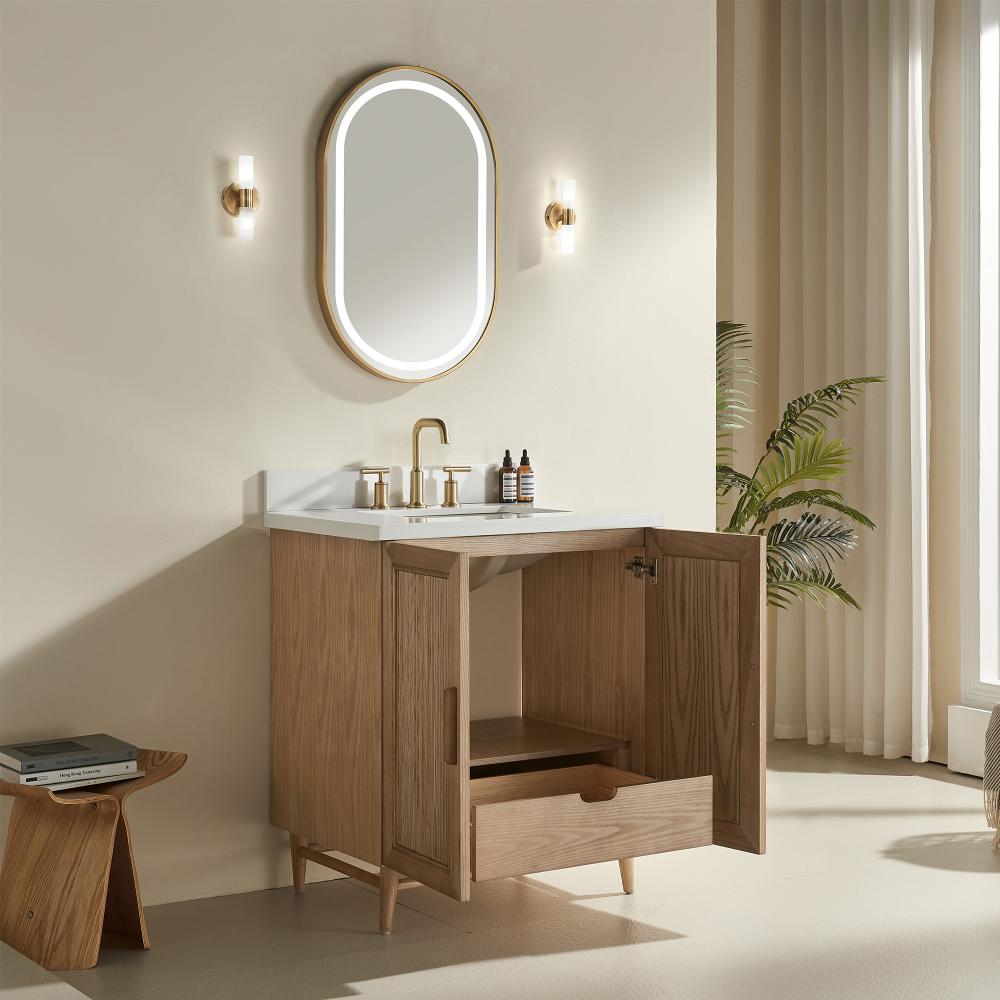 A modern bathroom showcases the Liora 36 Inch Bathroom Vanity with an open cabinet door and drawer, a white sink, gold faucet, oval mirror, wall lights, stool, and a potted plant by a window with sheer curtains.