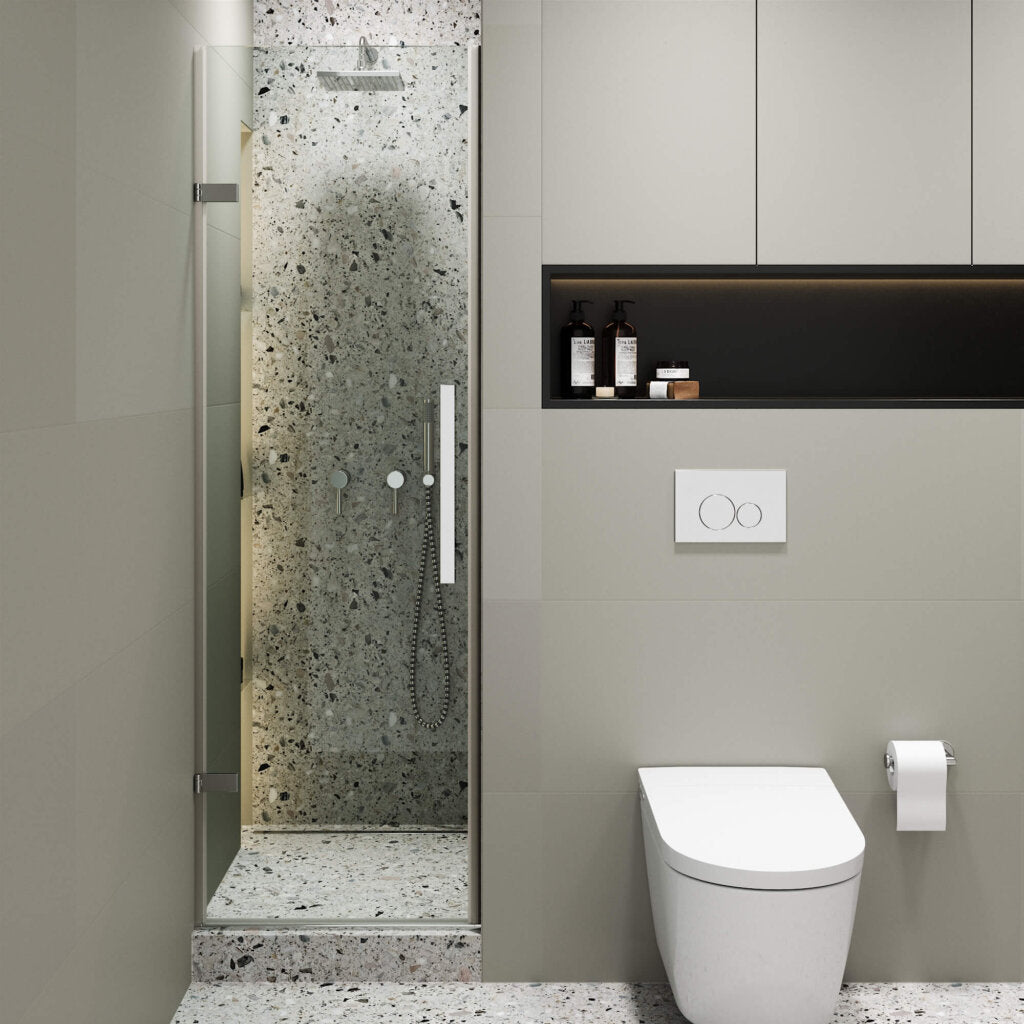 Modern bathroom featuring a terrazzo-tiled walk-in shower with the Nova Hinged Frameless Shower Door, wall-mounted toilet, toilet paper holder, and built-in shelf above the toilet. The minimalist design uses neutral tones.