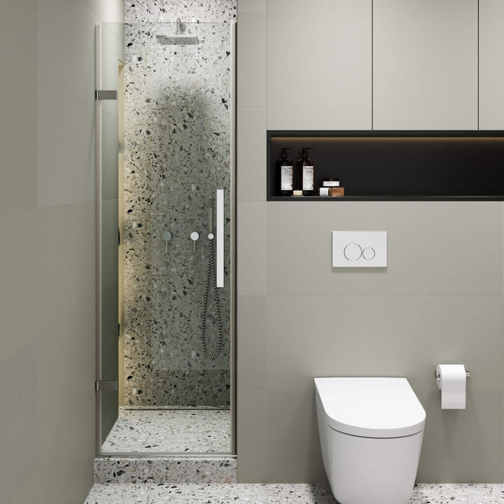 Modern bathroom featuring a terrazzo-tiled walk-in shower with the Nova Hinged Frameless Shower Door, wall-mounted toilet, toilet paper holder, and built-in shelf above the toilet. The minimalist design uses neutral tones.