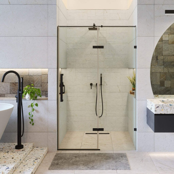 A modern bathroom featuring the Nova Hinged Frameless Shower Door with black fixtures, a freestanding bathtub, wall-mounted faucet, gray bath mat, round mirror, and plants for a touch of greenery.
