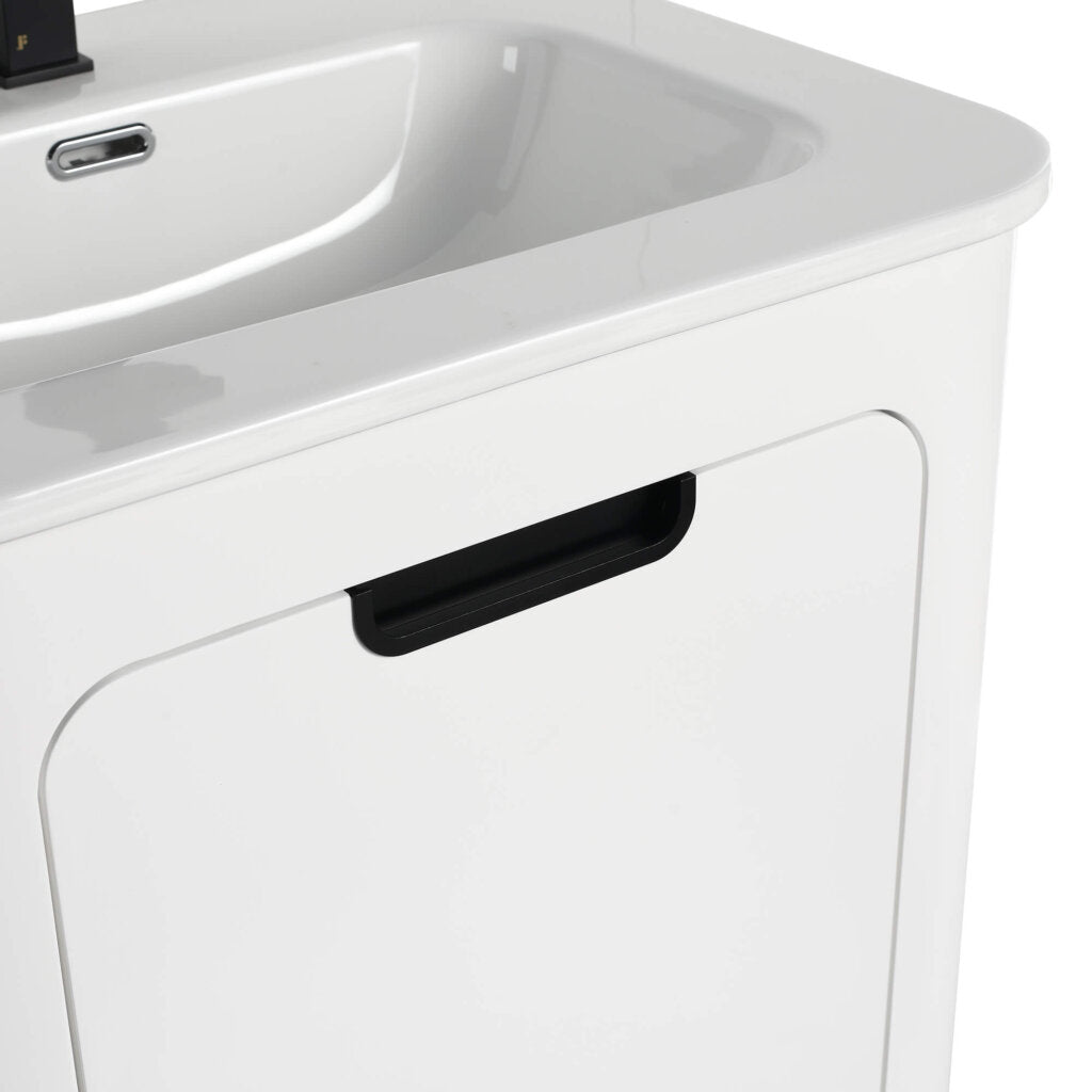 Close-up of the Shireplace 24 Inch Bathroom Vanity, highlighting its white minimalist design. It includes a black cabinet door handle under the integrated sink and a sleek faucet in the background.