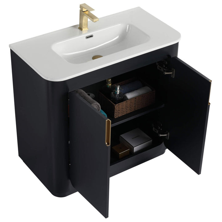 The Shireplace 36 Inch Bathroom Vanity With Sink flaunts a black design with a sleek white countertop and a gold faucet. Its open cabinet doors display towels and essentials, combining modern elegance with practical storage.