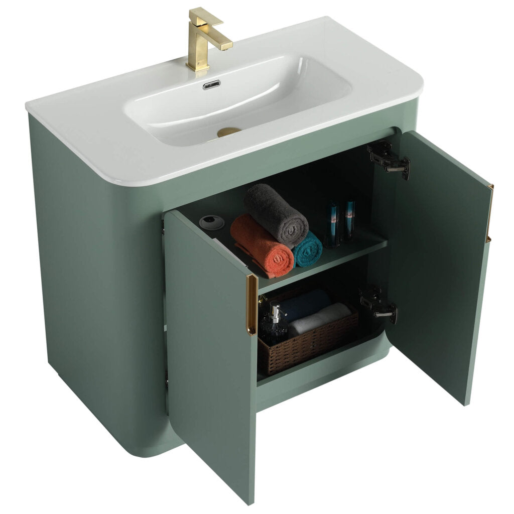 The Shireplace 36 Inch Bathroom Vanity With Sink features a modern green finish and white countertop with a gold faucet. Open cabinet doors reveal neatly stacked towels, bottles, and a basket on the shelves, enhancing its sleek, contemporary design.