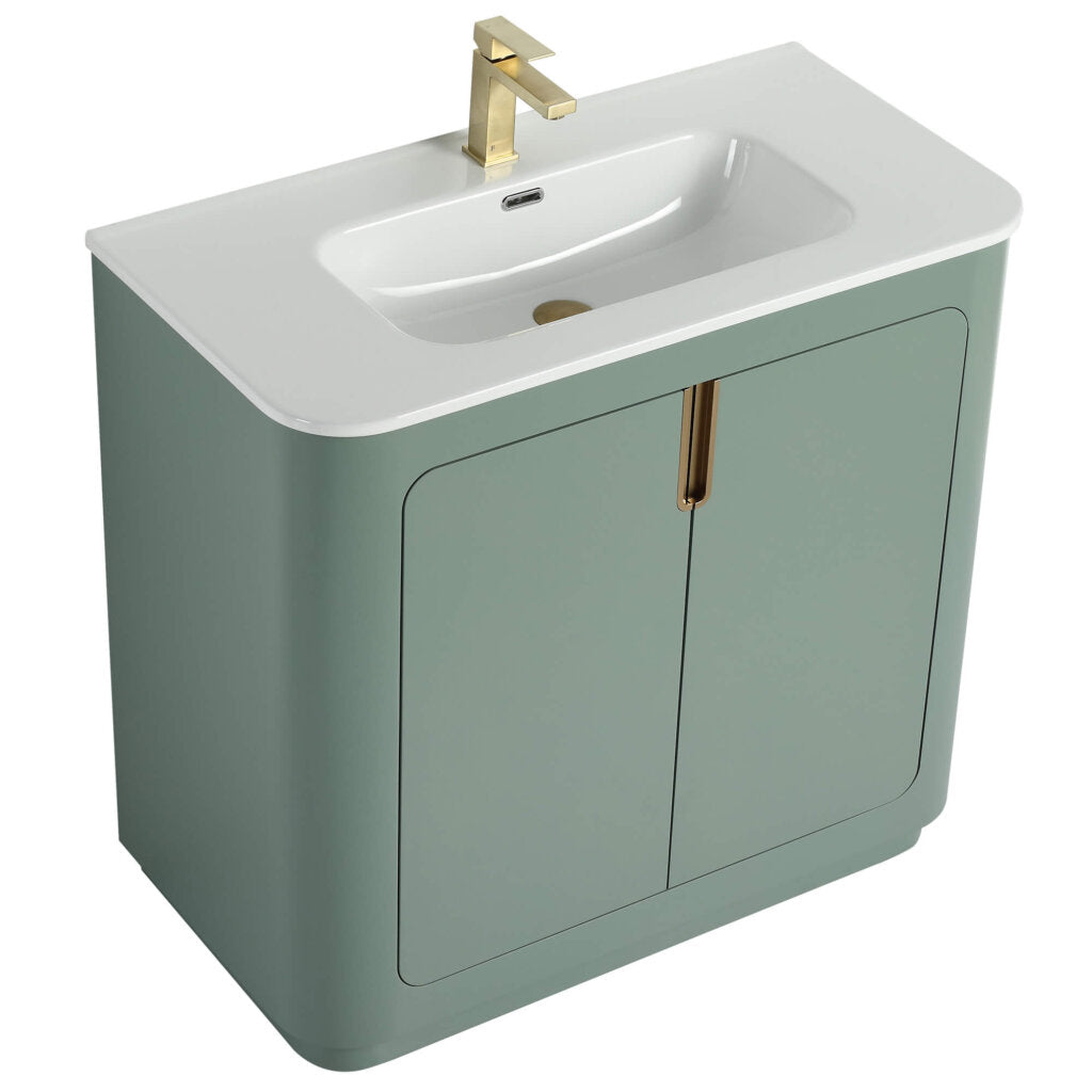 Introducing the Shireplace 36 Inch Bathroom Vanity With Sink, a modern gem featuring a soft green cabinet, white countertop, and built-in sink. It boasts a sleek gold faucet and two cabinet doors adorned with elegant gold handles, blending style and functionality seamlessly.
