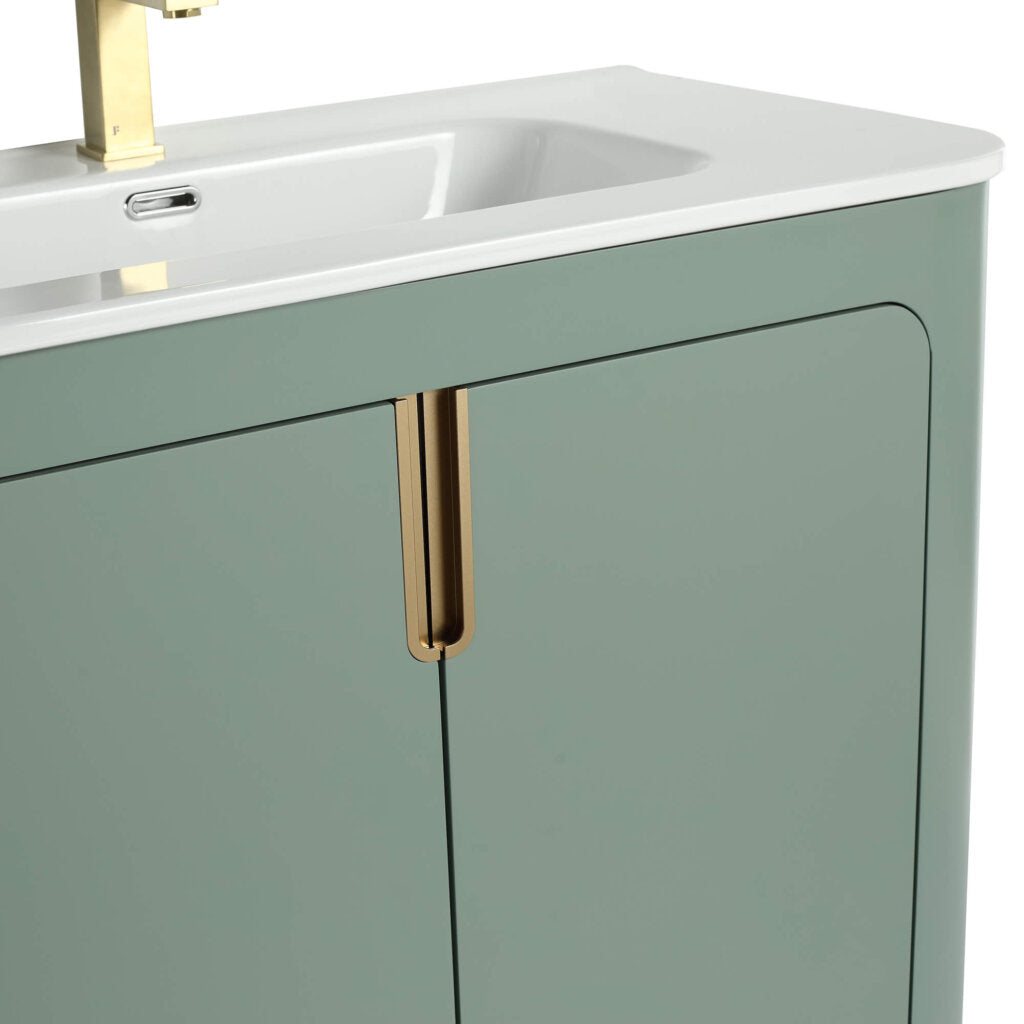 Close-up of the Shireplace 36 Inch Bathroom Vanity with Sink, showcasing a pale green cabinet and minimalist design. It features an integrated sink and gold-colored faucet, with vertical gold handles on the cabinet doors.