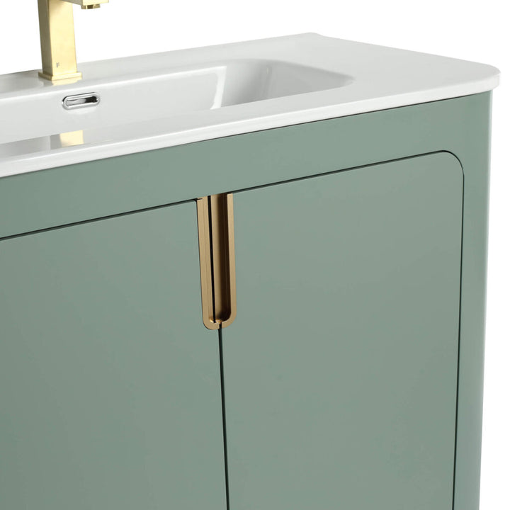 Close-up of the Shireplace 36 Inch Bathroom Vanity with Sink, showcasing a pale green cabinet and minimalist design. It features an integrated sink and gold-colored faucet, with vertical gold handles on the cabinet doors.