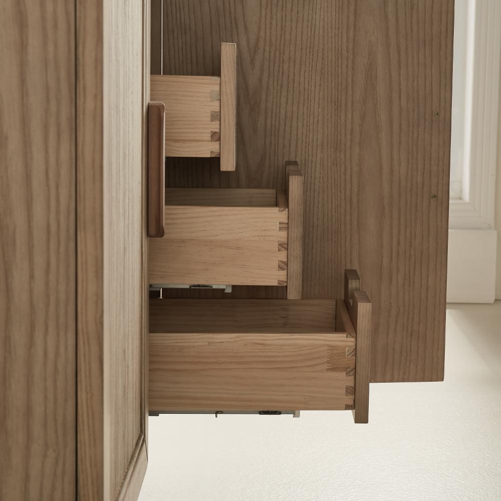 Close-up of three dovetail drawers partially open inside the Liora 30 Inch Bathroom Vanity, highlighting the quality craftsmanship and joinery. The light wood vanity stands against a light-colored wall and floor.