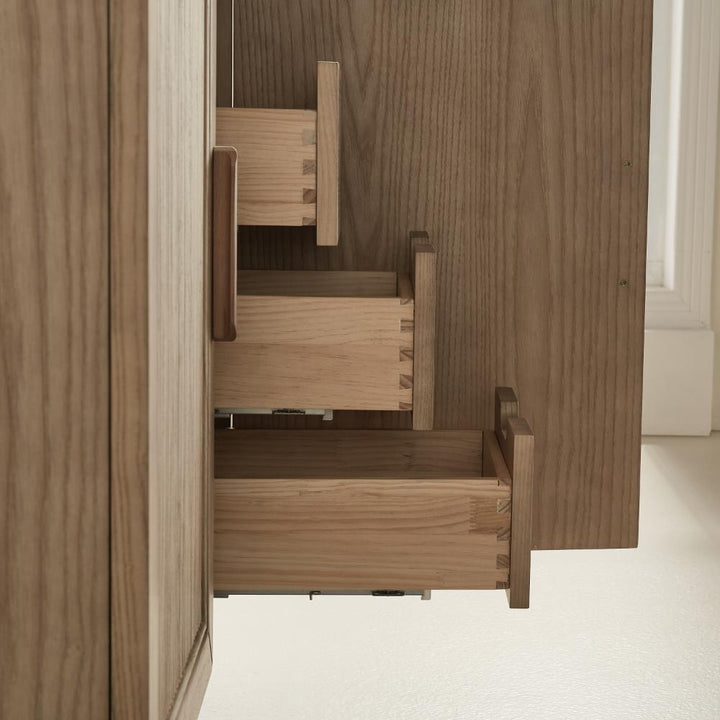 Close-up of three dovetail drawers partially open inside the Liora 30 Inch Bathroom Vanity, highlighting the quality craftsmanship and joinery. The light wood vanity stands against a light-colored wall and floor.