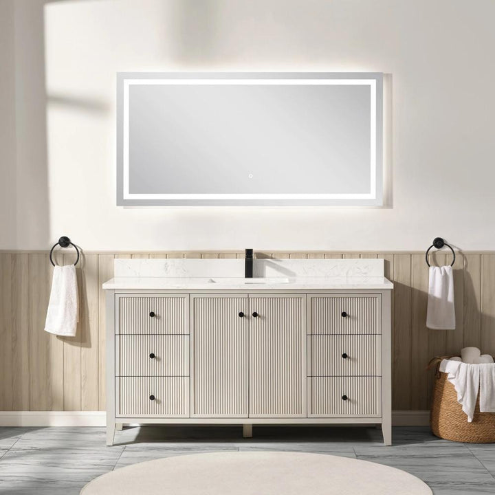 A modern bathroom showcases the Torino 60 Inch Single Bathroom Vanity with multiple drawers and a central cabinet, topped by a large illuminated mirror. Neutral, minimal decor includes towels on both sides and rolled towels on stools.