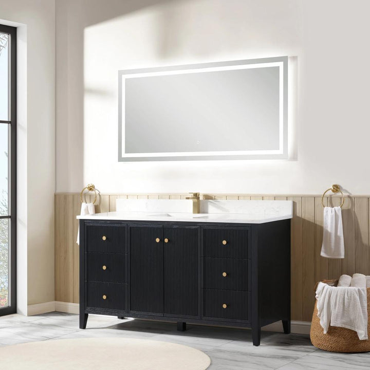 A modern bathroom features the Torino 60 Inch Single Bathroom Vanity in black with gold hardware, a white countertop, gold faucet, and towel rings. Light wood paneling and a basket with towels sit beside the vanity as natural light fills the room.
