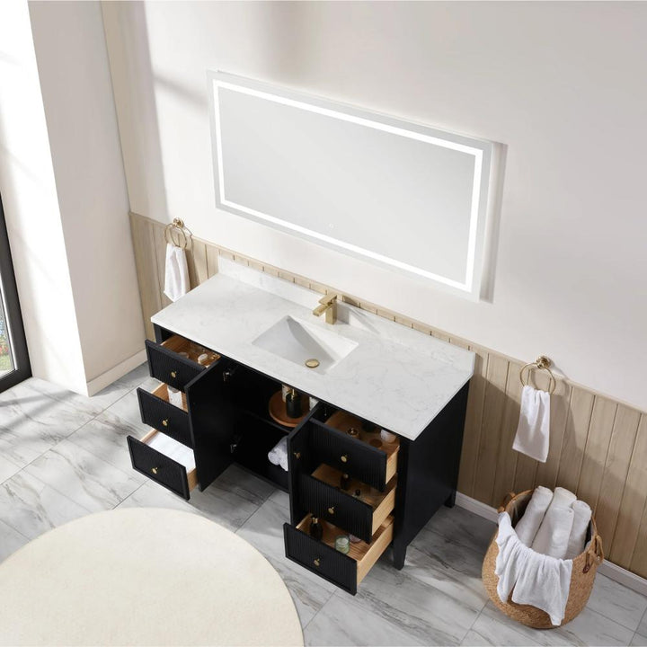 The Torino 60 Inch Single Bathroom Vanity features a white marble countertop, rectangular sink, gold faucet, black cabinets with open drawers, and is complemented by a large illuminated mirror above with towels and baskets nearby.