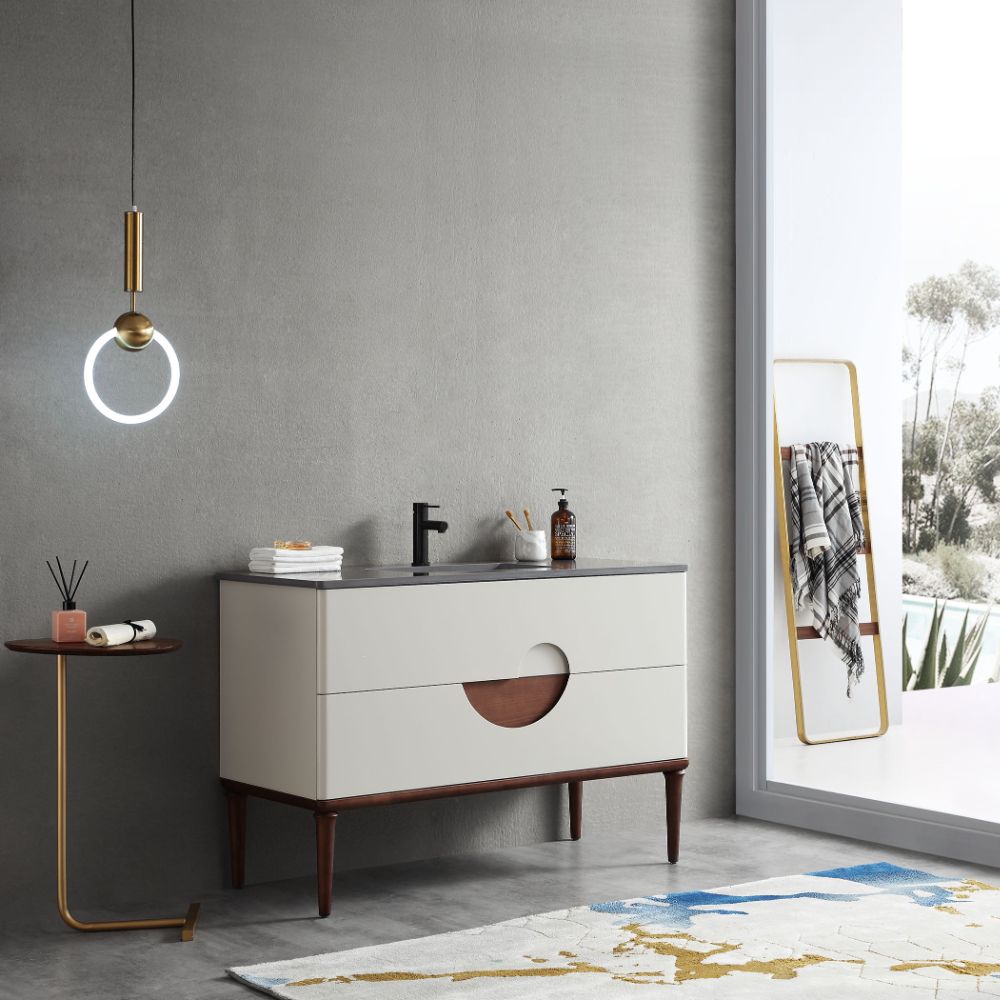 Modern bathroom with the Burano 48 inch Beige Freestanding Bathroom Vanity, round pendant light, small side table and decor, large window reflecting trees, a blanket on the standing mirror, and a patterned rug completing the look.
