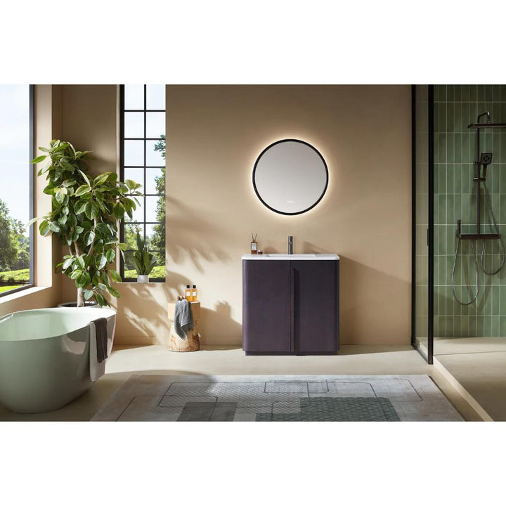 Modern bathroom featuring a Parma 36 Inch Bathroom Vanity With Top, round backlit mirror, freestanding tub, large plant, green-tiled walk-in shower, and sunlight streaming through tall windows.