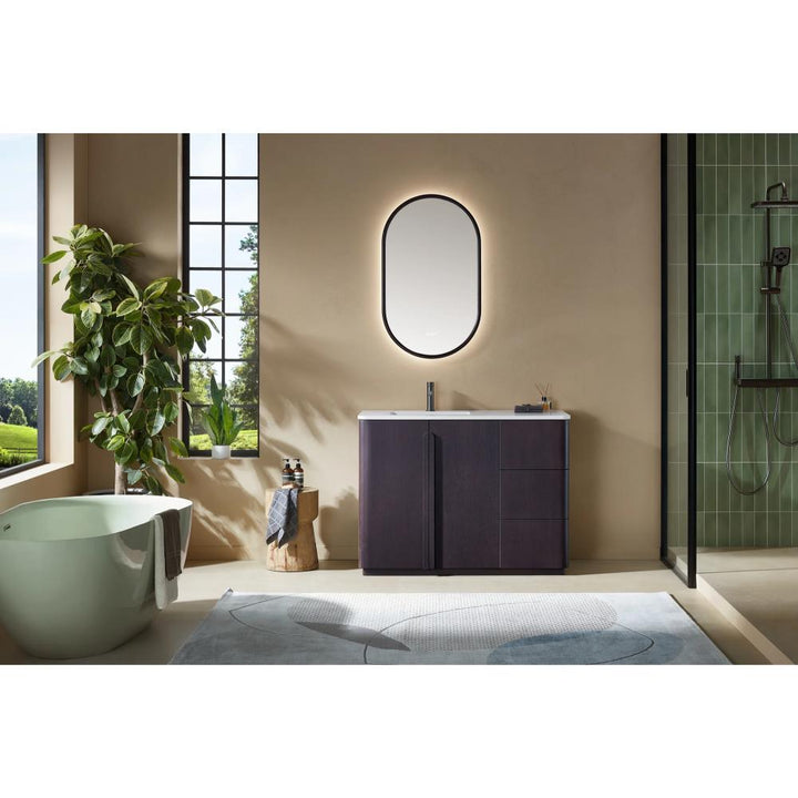 Modern bathroom featuring a Parma 48 Inch Bathroom Vanity With Top, a freestanding tub, oval backlit mirror, large window, green plant, and a glass-enclosed shower with green tile walls. Natural light fills the space.