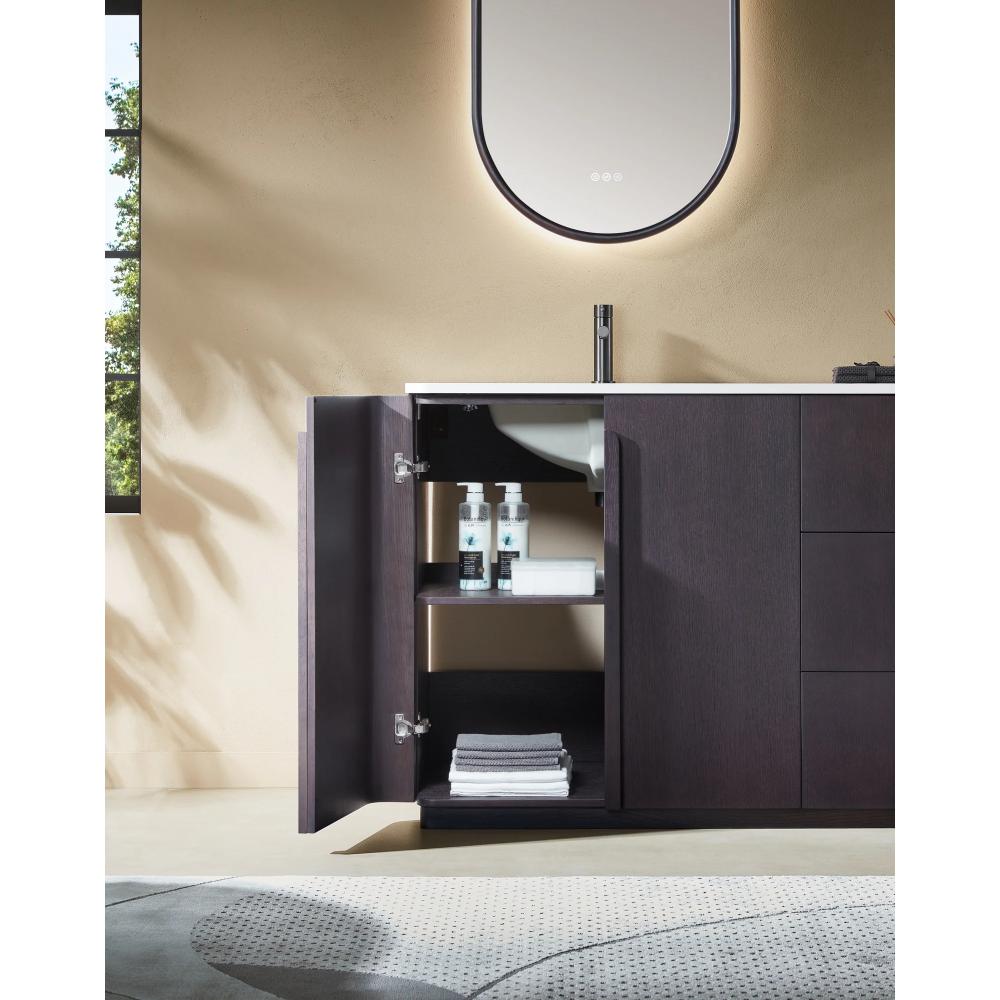 The Parma 48 Inch Bathroom Vanity With Top features dark wood cabinets and a door opening to shelves with towels and bottles, set beneath a curved, softly backlit mirror. A window and part of a patterned rug are also visible.