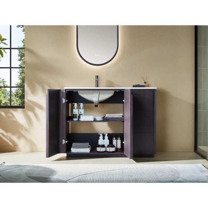 The Parma 48 Inch Bathroom Vanity With Top features open cabinet doors displaying neatly arranged shelves with towels and supplies. Above the vanity are a white sink, tall faucet, and rounded rectangular mirror for a modern look.