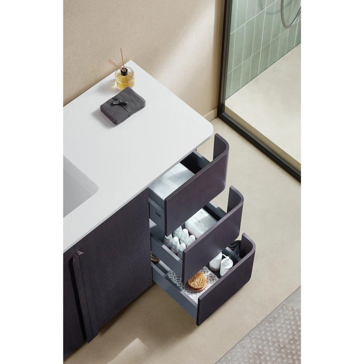 Overhead view of a Parma 48 Inch Bathroom Vanity With Top featuring three open drawers, neatly organized towels, bottles, and toiletries beside a white countertop and a walk-in shower with glass doors.