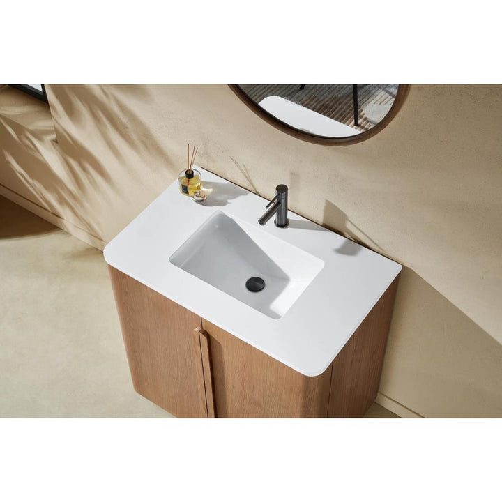 Overhead view of a modern bathroom featuring the Parma 36 Inch Bathroom Vanity With Top, with a white rectangular sink, sleek silver faucet, round mirror, and small accessories like a diffuser and bottle on the counter.