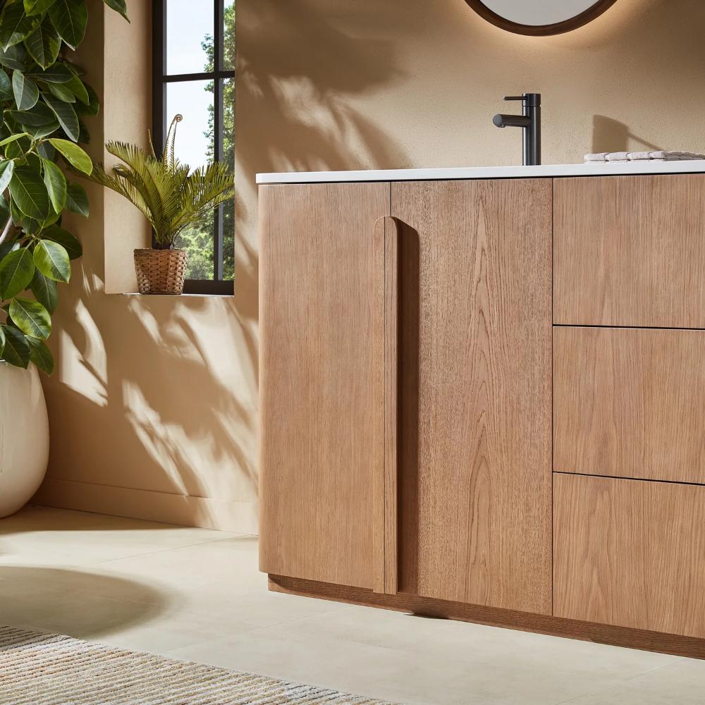 Modern bathroom featuring the Parma 48 Inch Bathroom Vanity With Top, a tall vertical handle, white countertop, black faucet, indoor plant by a window, and natural light streaming in.