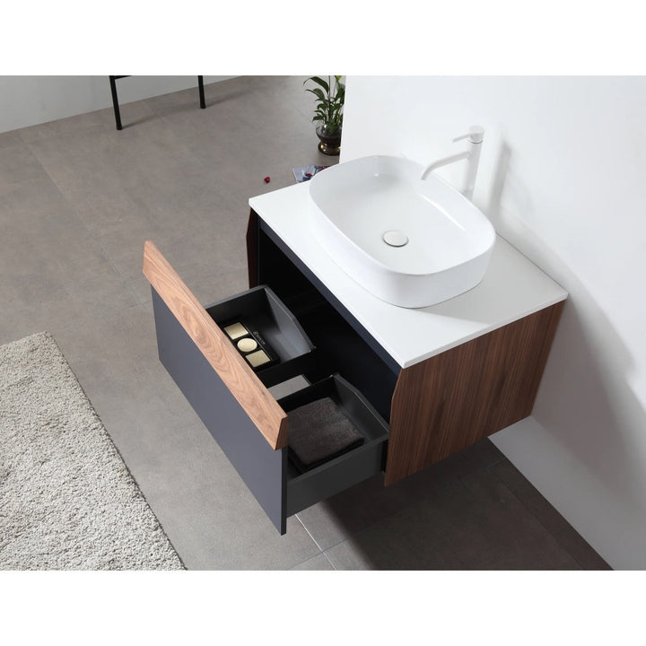 The Ronda 30 Inch Wall Mount Bathroom Vanity with vessel sink features wood and black drawers, partially open to reveal towels and toiletries, set against a gray tiled floor with a rug and plant in the background.