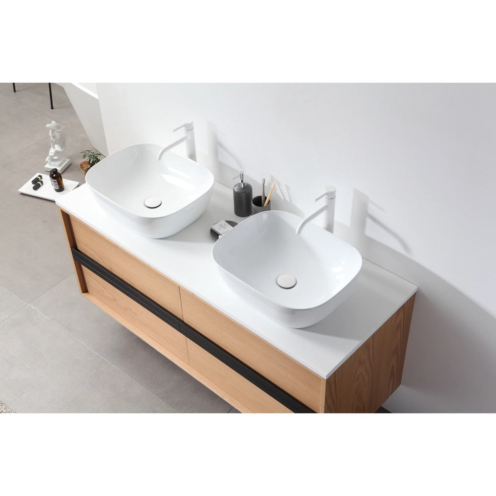 The Sintra 55 Inch Wall Mount Vanity with Double Vessel Sinks includes a light wood cabinet, white countertop, two square vessel sinks, white faucets, and minimal accessories for a clean, modern look.