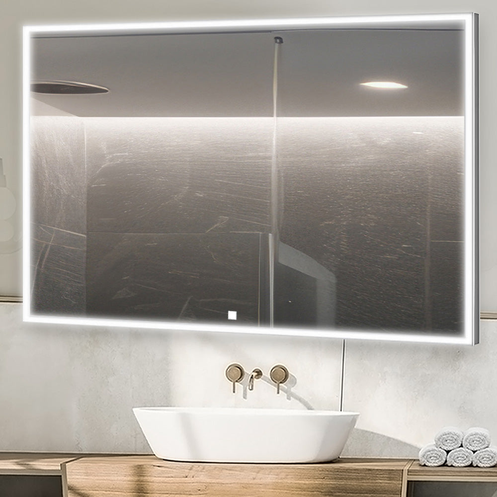 A modern bathroom features the Edge 48 Inch LED Lighted Bathroom Mirror above a white vessel sink with a wall-mounted faucet, while rolled towels are neatly stacked on the wooden countertop below.