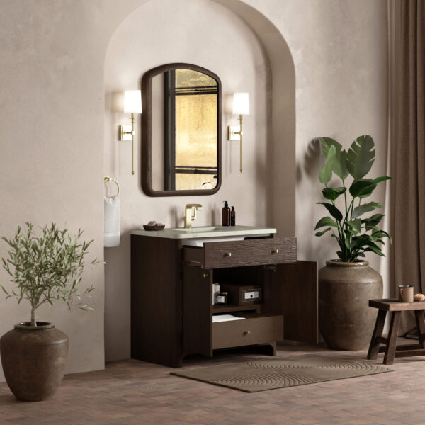 Bathroom with an arched alcove featuring a Gracyn 36 inch Bathroom Vanity with a white countertop. An oval mirror is flanked by wall sconces, while potted plants and a small wooden stool enhance the warm, earthy tone of the space.